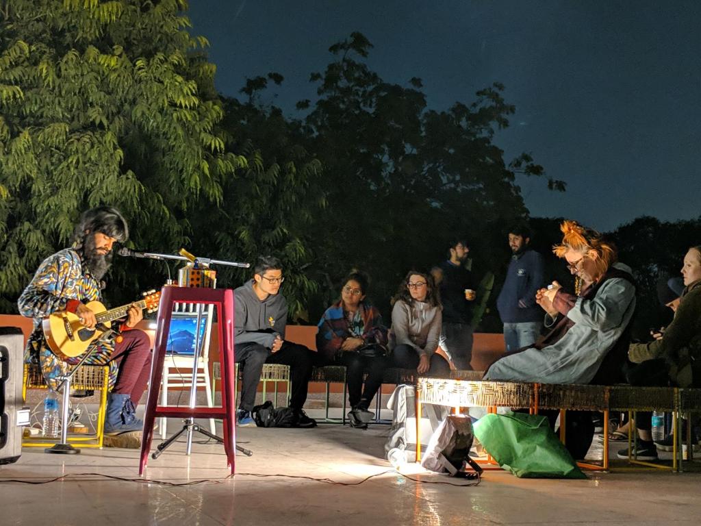un groupe de personnes sur scène jouant de la musique dans l'établissement Jaipur Jantar Hostel, à Jaipur
