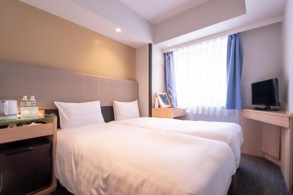 Postel nebo postele na pokoji v ubytování E Hotel Higashi Shinjuku