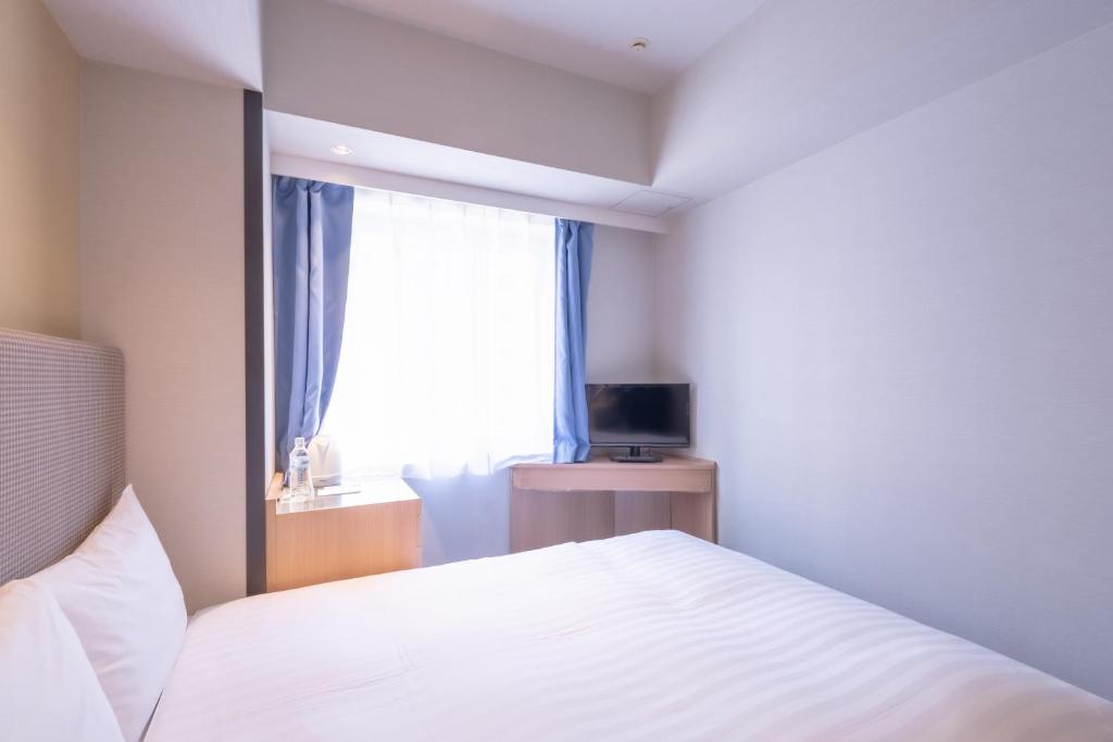 Postel nebo postele na pokoji v ubytování E Hotel Higashi Shinjuku