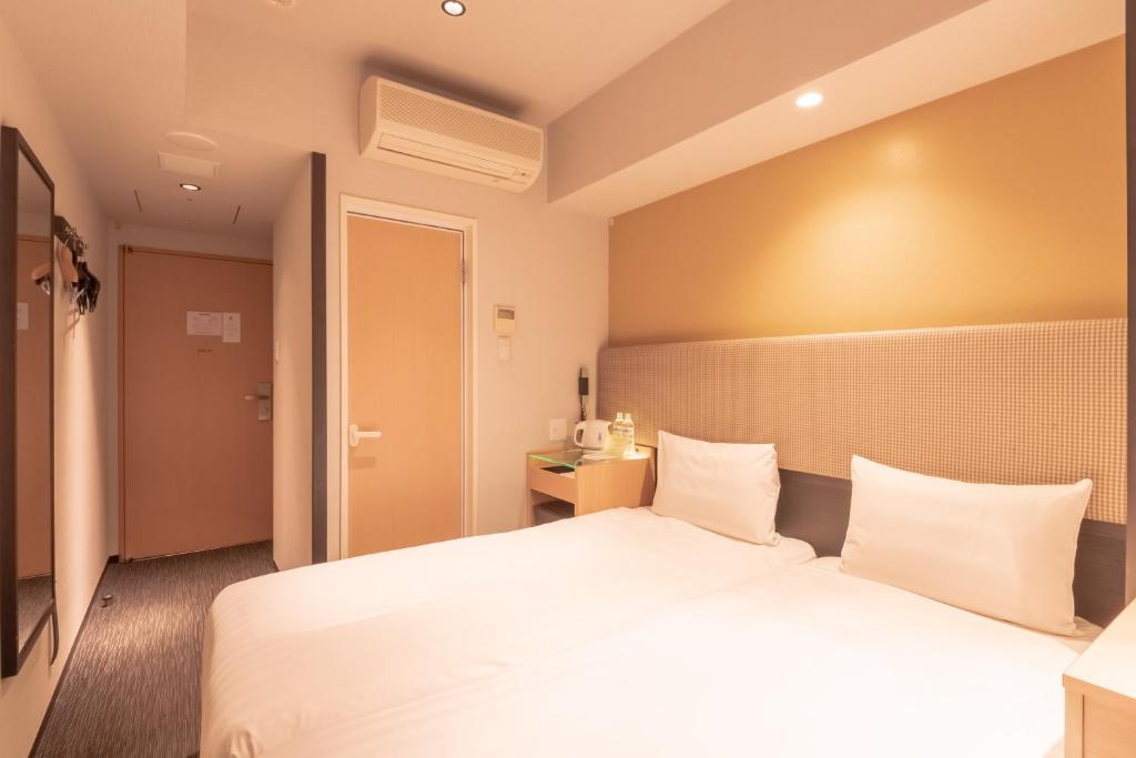 Postel nebo postele na pokoji v ubytování E Hotel Higashi Shinjuku