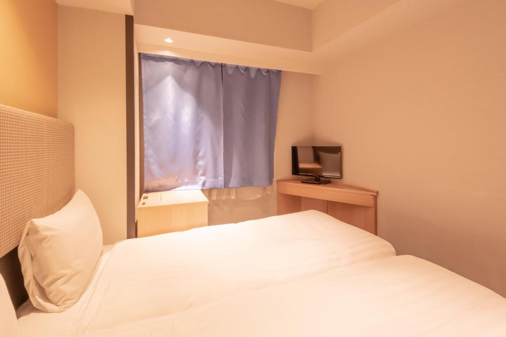 Postel nebo postele na pokoji v ubytování E Hotel Higashi Shinjuku