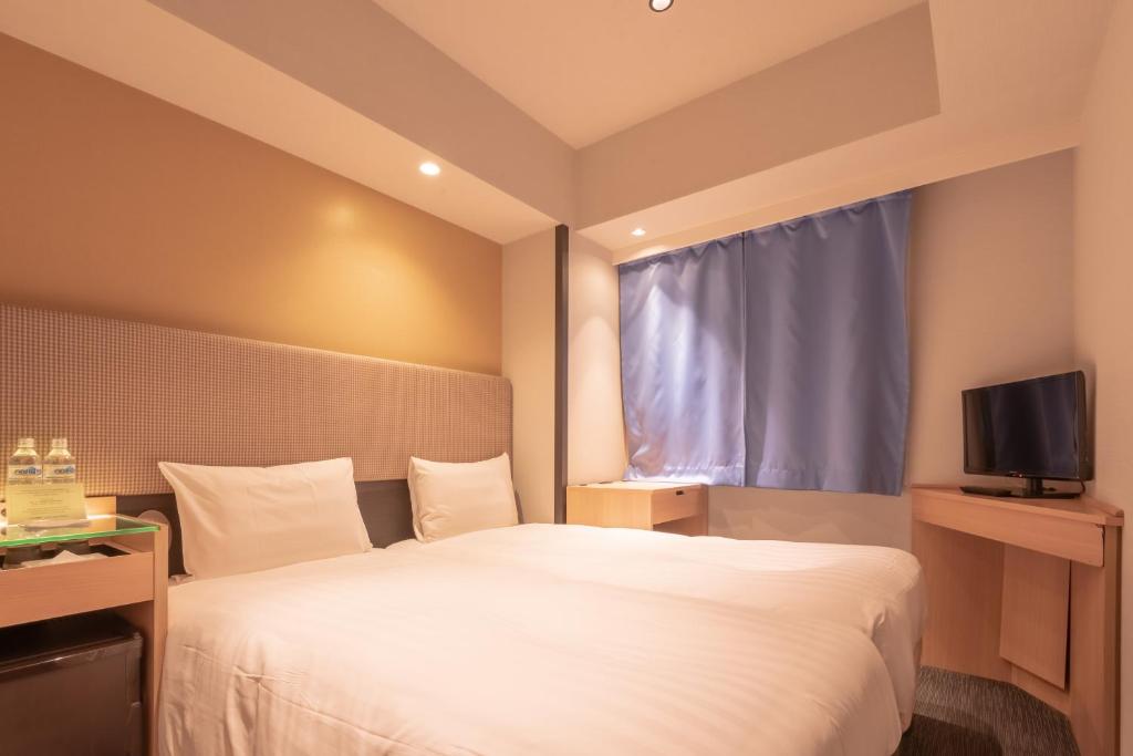 Postel nebo postele na pokoji v ubytování E Hotel Higashi Shinjuku