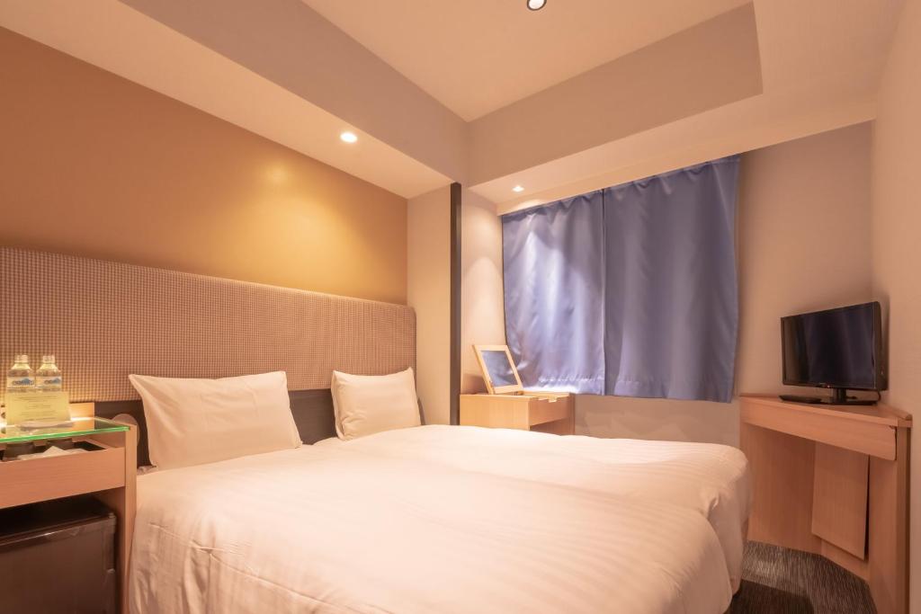 Postel nebo postele na pokoji v ubytování E Hotel Higashi Shinjuku