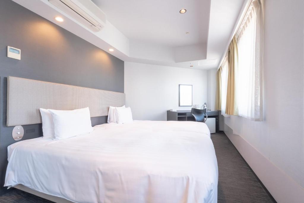 Postel nebo postele na pokoji v ubytování E Hotel Higashi Shinjuku