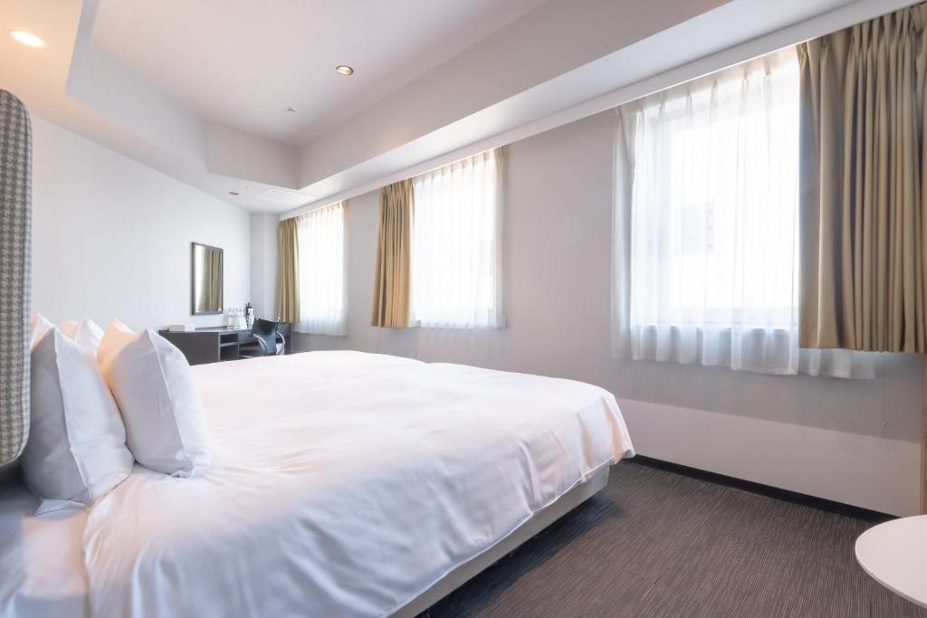 Postel nebo postele na pokoji v ubytování E Hotel Higashi Shinjuku