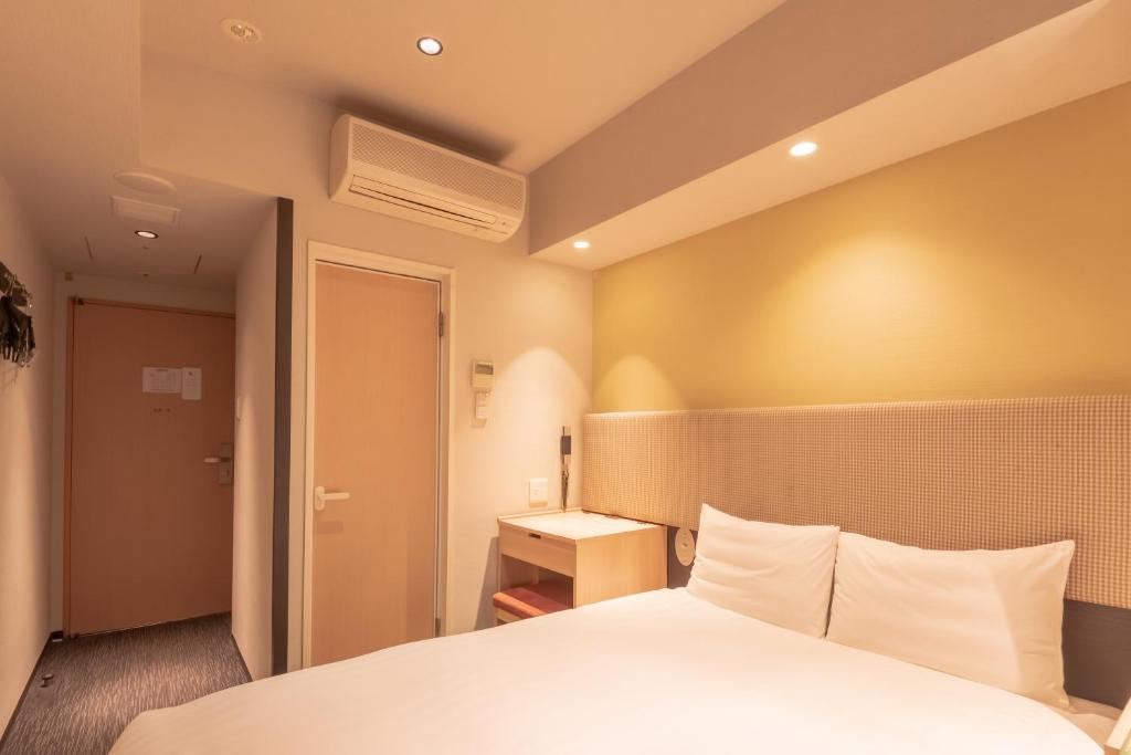 Postel nebo postele na pokoji v ubytování E Hotel Higashi Shinjuku