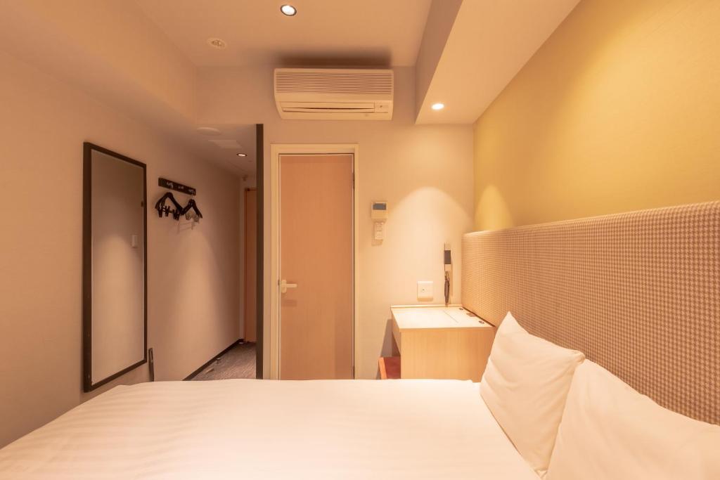 Postel nebo postele na pokoji v ubytování E Hotel Higashi Shinjuku