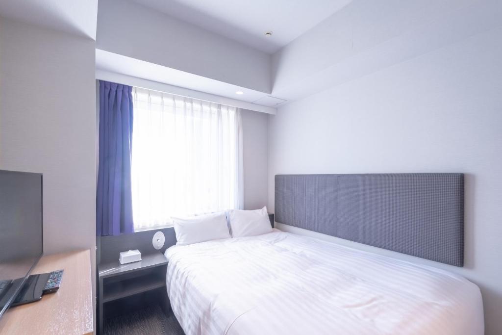 Postel nebo postele na pokoji v ubytování E Hotel Higashi Shinjuku