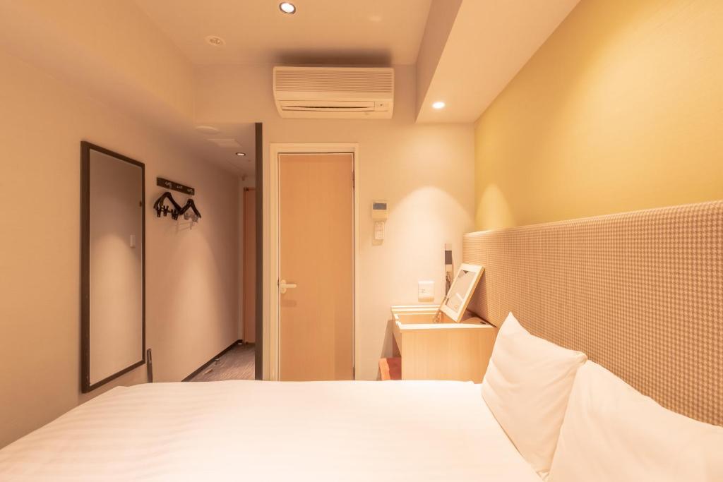 Postel nebo postele na pokoji v ubytování E Hotel Higashi Shinjuku