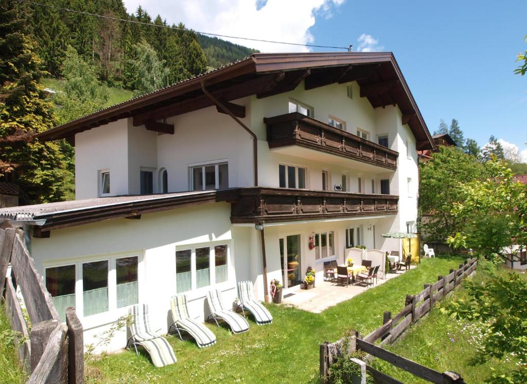 a house with lounge chairs in front of it at Ferienwohnung Mondial in Neustift im Stubaital