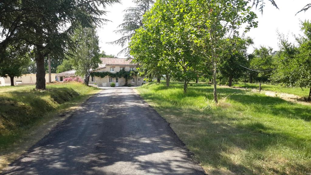 une route vide avec une maison au loin dans l'établissement Gîte de Beausoleil, à La Romieu