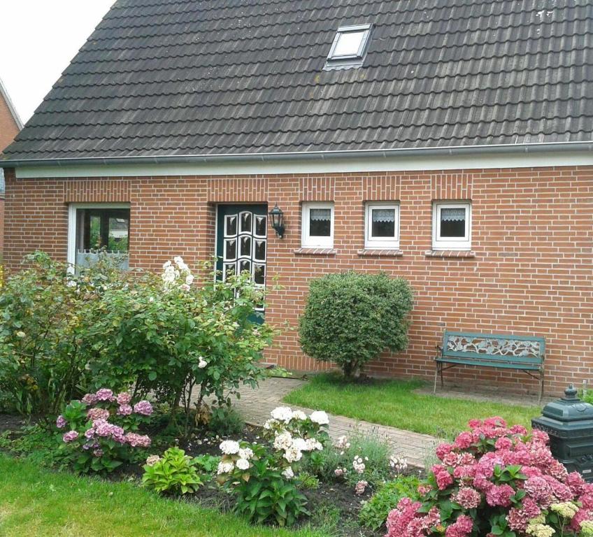 a brick house with a bench in the yard at Luettje-Glueck in Pogum