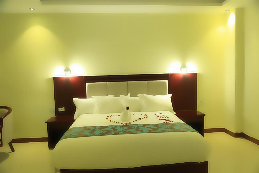 a bedroom with a large bed with two lights on it at Winn Hotel - Bahir Dar in Bahir Dar