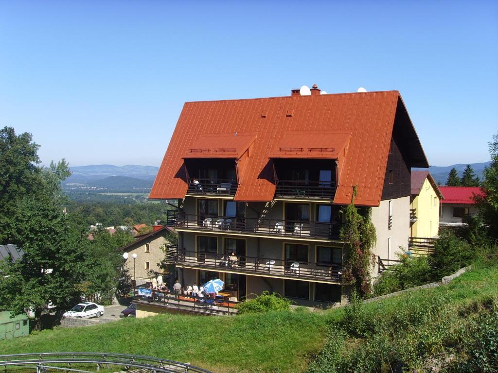 a building with an orange roof on a hill at Ośrodek Wypoczynkowy Pod Stokiem in Karpacz