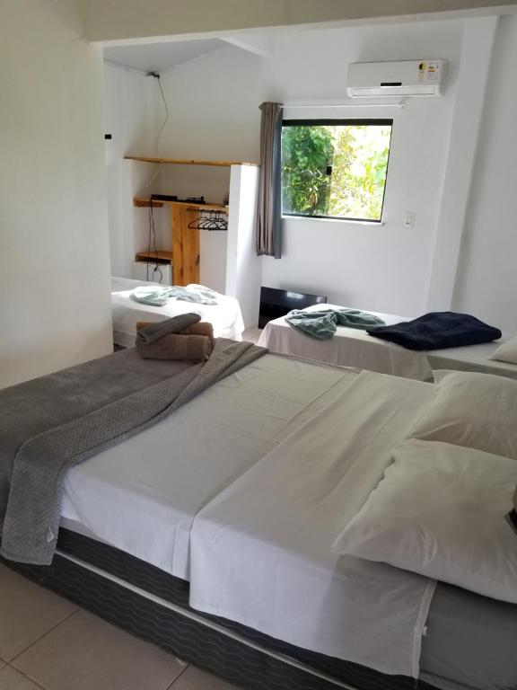 duas camas em um quarto com janela em Pousada Tulum em Barra Grande