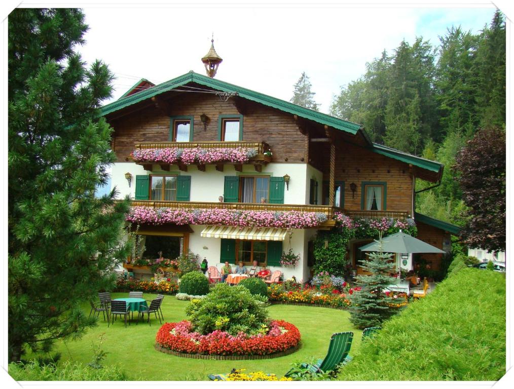 a large house with flowers in the yard at Landhaus Teufl in Faistenau