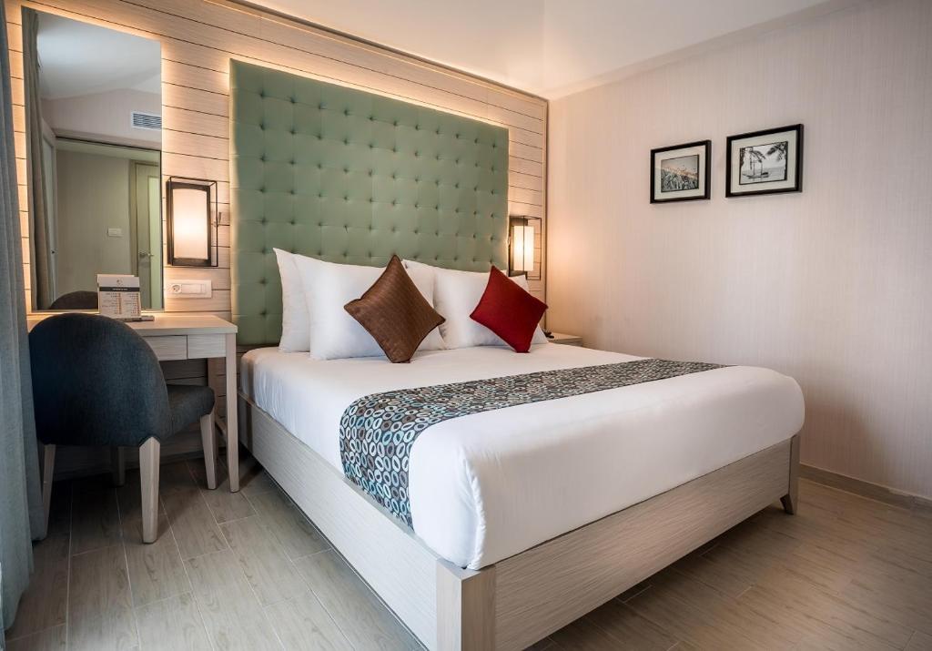 Postel nebo postele na pokoji v ubytování Astral Village Hotel