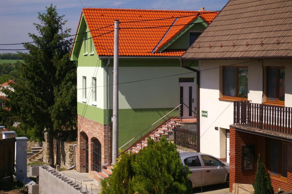 a green and white house with a car parked in front at Penzion Buriánkovi in Hlohovec