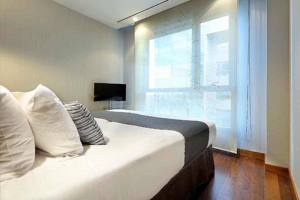 a bedroom with a large white bed with a window at Eurostars Madrid Congress in Alcobendas