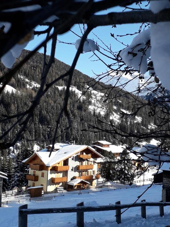 a building in the snow with a mountain in the background at Casa Vacanze Michela in Santa Caterina Valfurva
