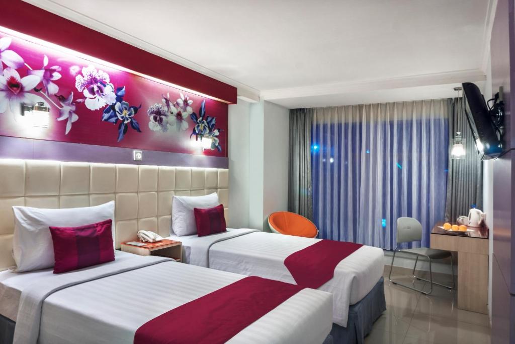 um quarto de hotel com duas camas num quarto em favehotel Premier Cihampelas em Bandung