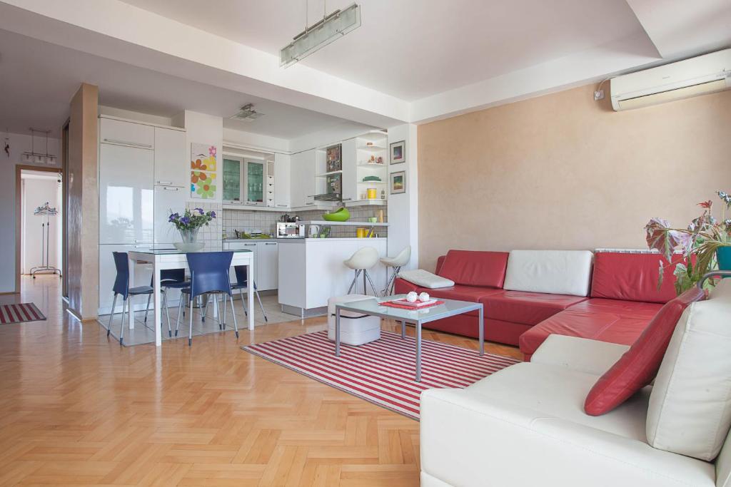 Una sala de estar con un sofá rojo y una cocina. en RED APARTMENT, en Skopje