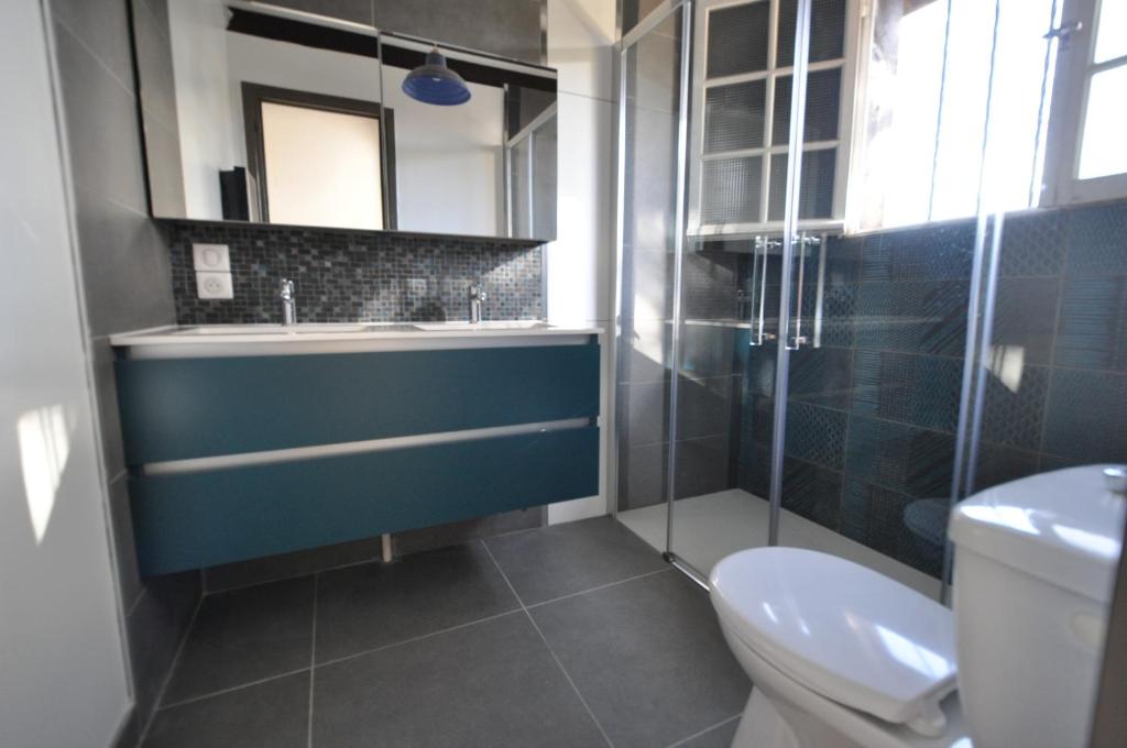 a bathroom with a blue sink and a toilet at Les 3 meninos in Vieux-Boucau-les-Bains