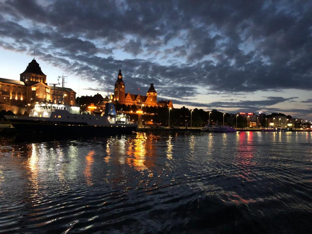 un bateau est amarré dans l'eau la nuit dans l'établissement COCO Love Adults Only Apartament Szczecin, à Szczecin