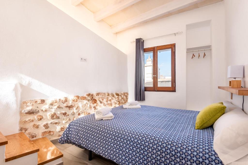 una camera bianca con un letto e una finestra di SA CASETA a Ciutadella