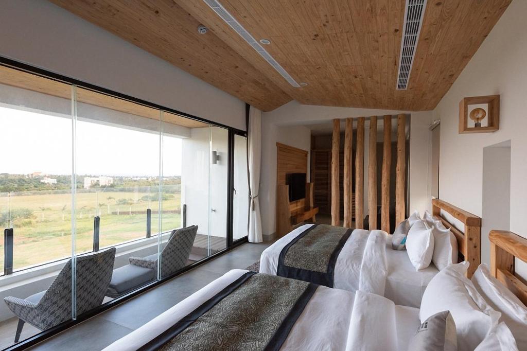 a bedroom with two beds and a large window at SkyeBay Club in Hengchun