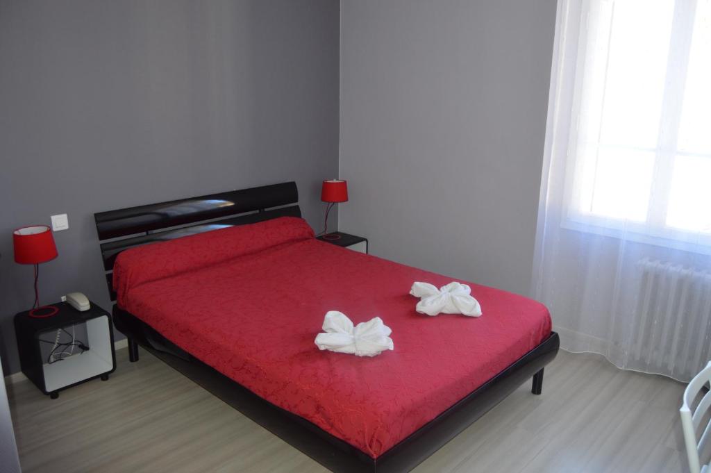 a bedroom with a red bed with two white flowers on it at Hôtel Restaurant Le Bellevue in Ax-les-Thermes