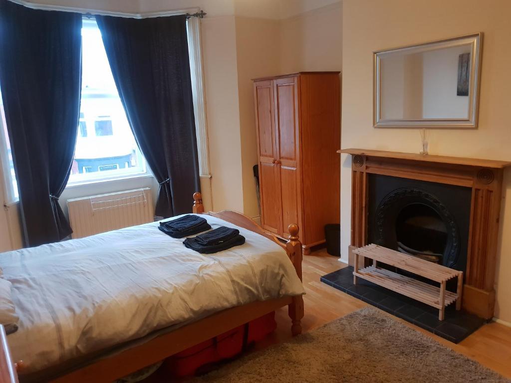 a bedroom with a bed with a fireplace and a television at Jesmond Vale 3 Bedroom Apartment in Newcastle upon Tyne