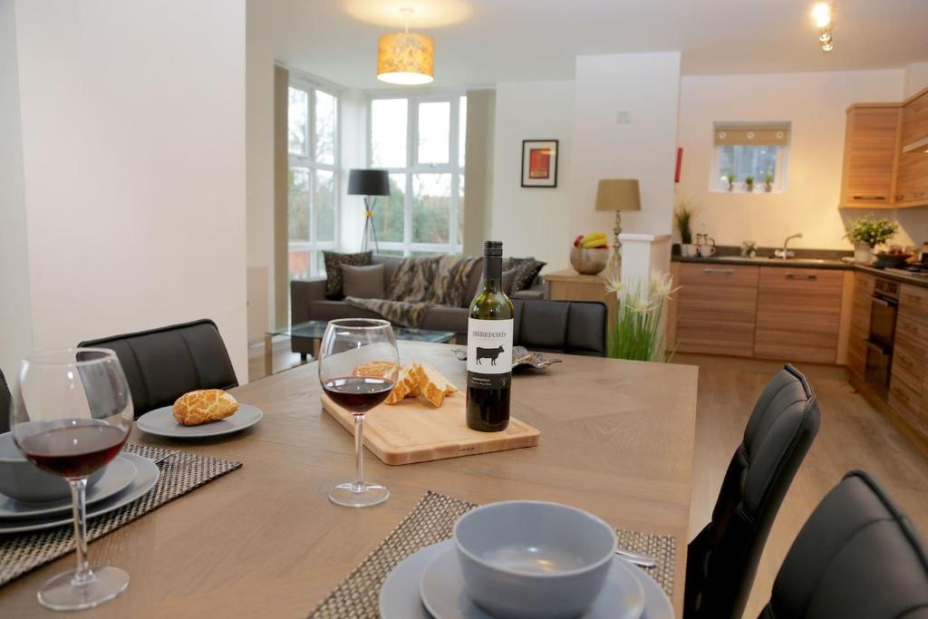 una mesa con copas de vino y una botella de vino en Wilford View en Nottingham