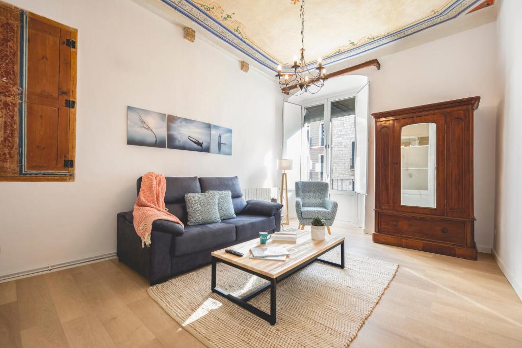 a living room with a couch and a coffee table at Bravissimo Plaça del Vi, Authentic Historic Apartment in Girona