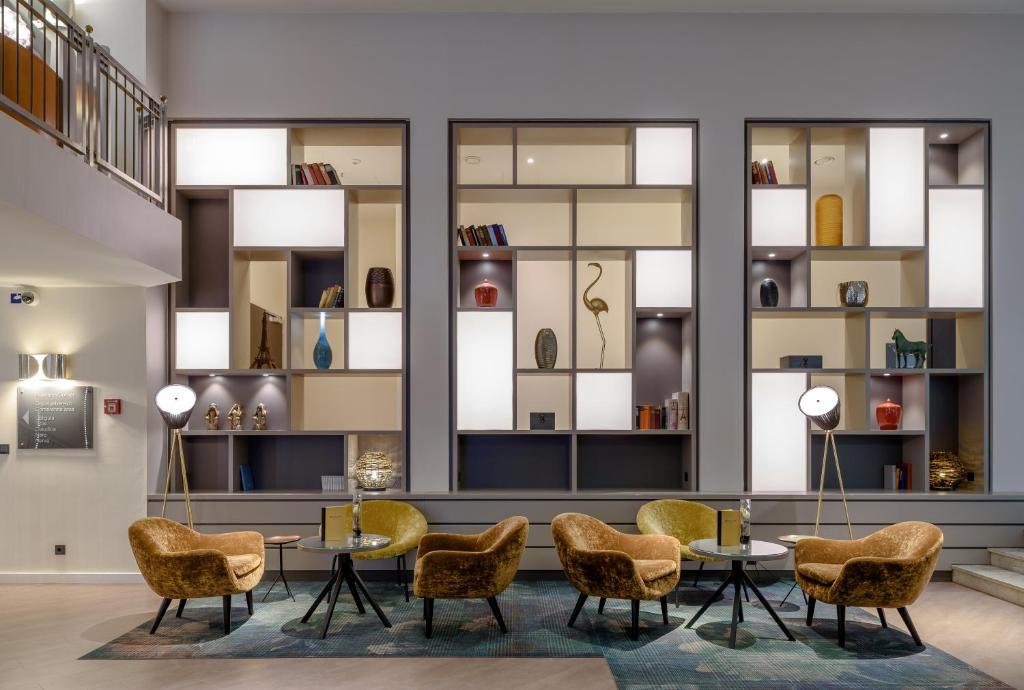eine Lobby mit Tischen, Stühlen und Fenstern in der Unterkunft Mercure Hotel Dortmund Centrum in Dortmund