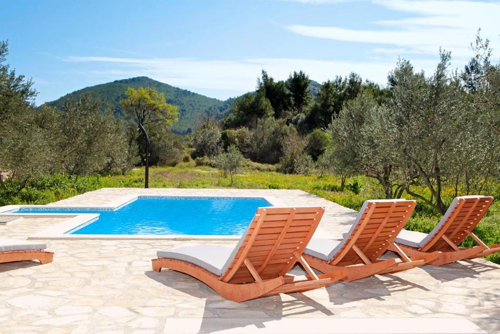 2 sillas y una piscina en un patio en Villa Mariela in Korcula, heated pool, en Vela Luka