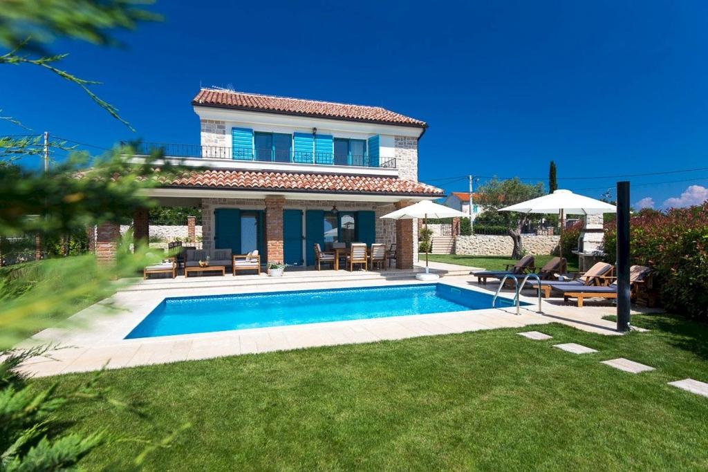 een huis met een zwembad in de tuin bij Luxury Villa Maša in Dobrinj