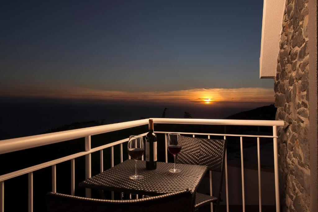 einen Tisch mit zwei Gläsern Wein auf dem Balkon in der Unterkunft Casa Tiana in Ponta do Sol