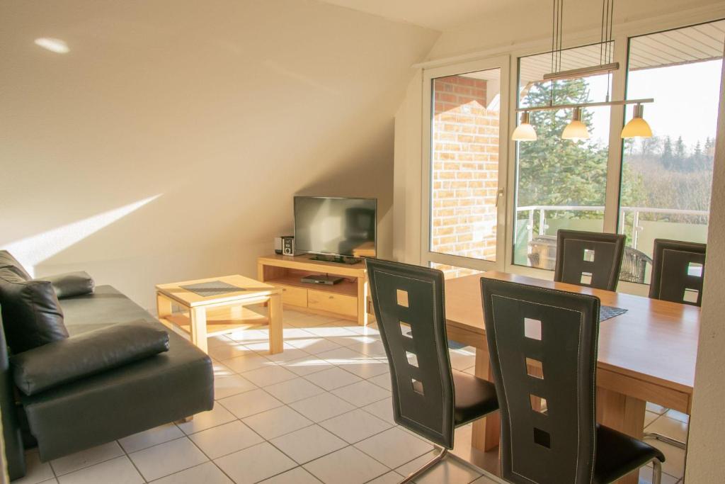 ein Wohnzimmer mit einem Esstisch und Stühlen in der Unterkunft Appartement Seeluft 17 - Durchatmen und Entspannen in Timmendorfer Strand
