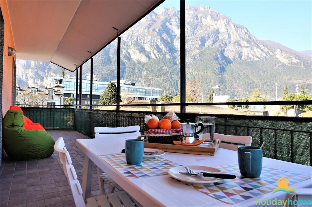 un tavolo su un balcone con vista sulle montagne di CASA GARDA BLU a Riva del Garda