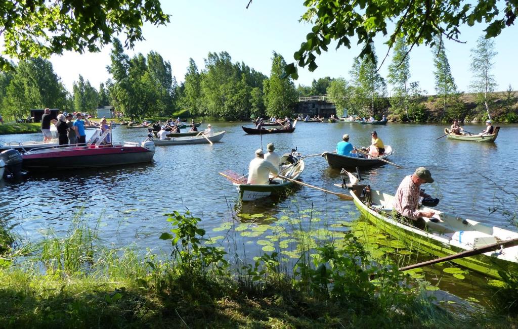 um grupo de pessoas em barcos em um rio em Hotelli Lohikontti em Parikkala