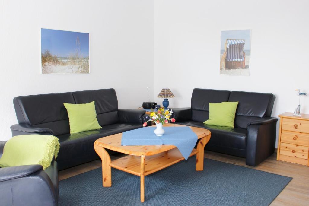 a living room with a black couch and a table at Meeresblick Fehmarn Ferienhaus 42 in Fehmarn