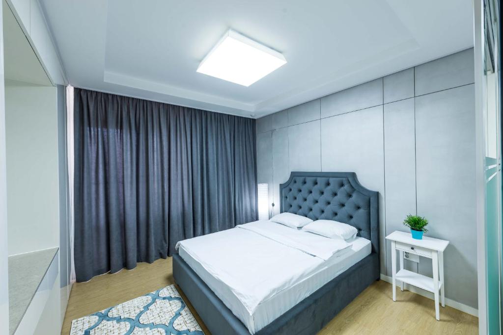 a bedroom with a large bed and a nightstand and a bed sidx sidx sidx at THEADDRESS HIGHVILL Lux in Astana
