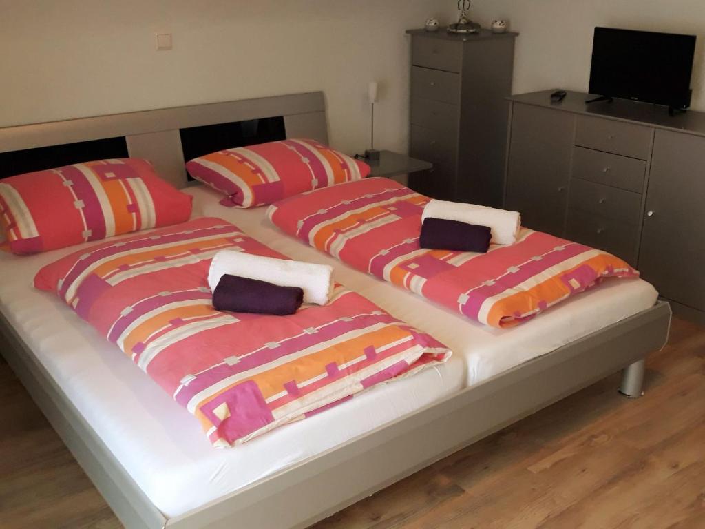 2 Betten mit bunten Decken in einem Schlafzimmer in der Unterkunft Ferienhaus Brit in Tailfingen