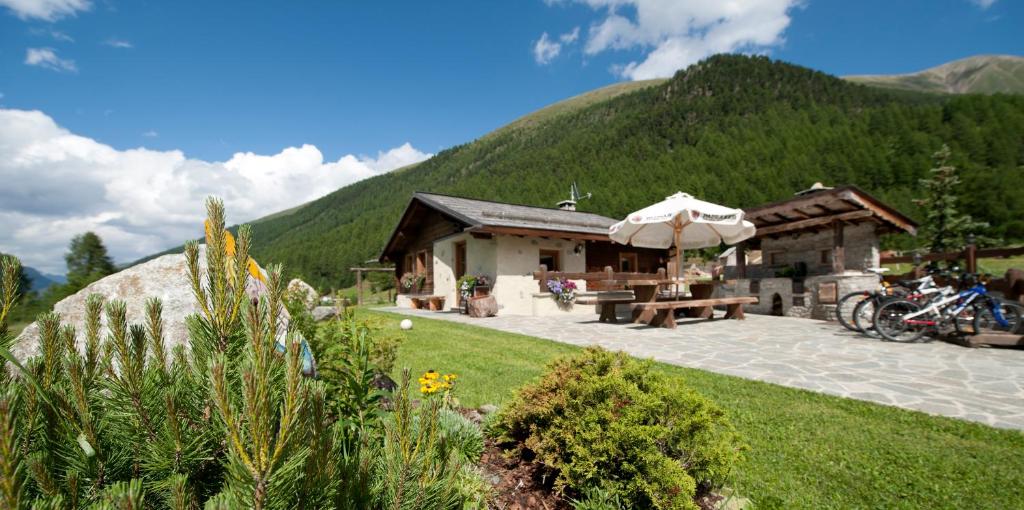 a building with a picnic table and an umbrella at Chalet in Via Dali Mina in Livigno