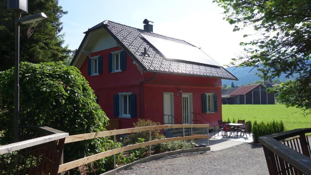 a red house with a fence in front of it at Erwins Ferien-Paradies in Hörbranz