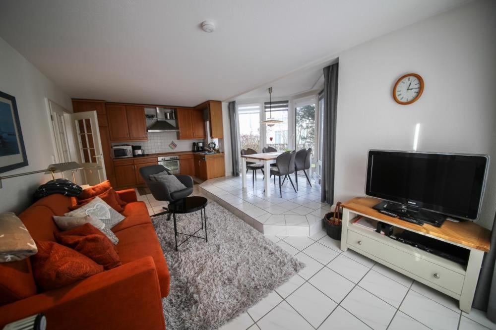 ein Wohnzimmer mit einem Sofa und einem Flachbild-TV in der Unterkunft Ferienwohnung Witthus in Scharbeutz