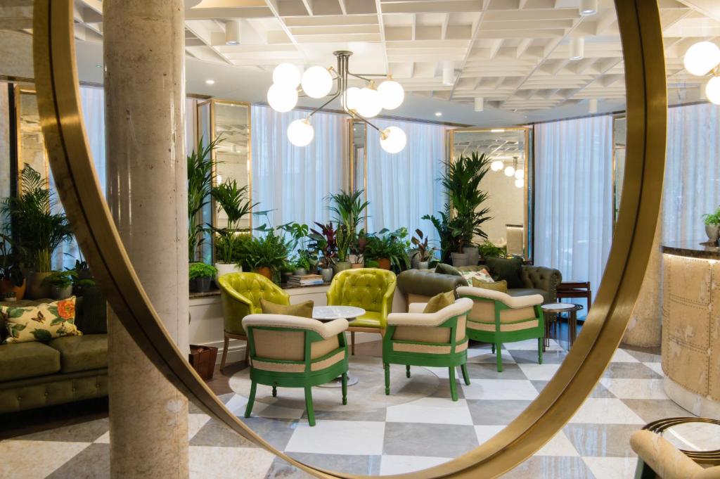 a mirror in a lobby with chairs and tables at Vintry & Mercer in London