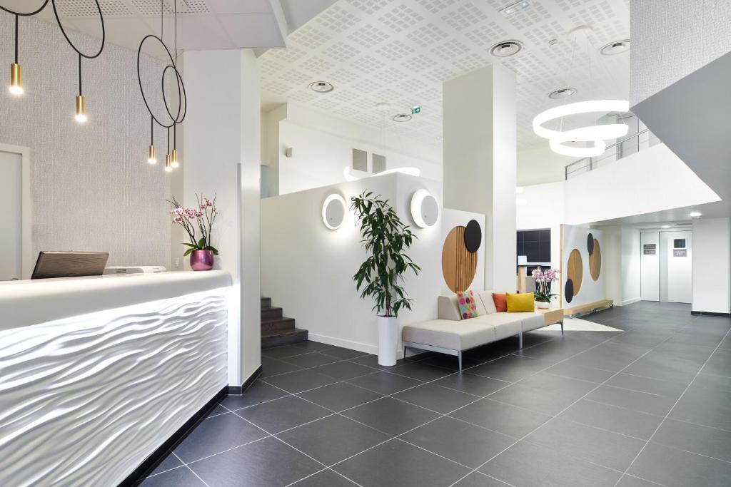 an office lobby with a reception desk and a waiting area at Hôtel Le Bayonne in Bayonne