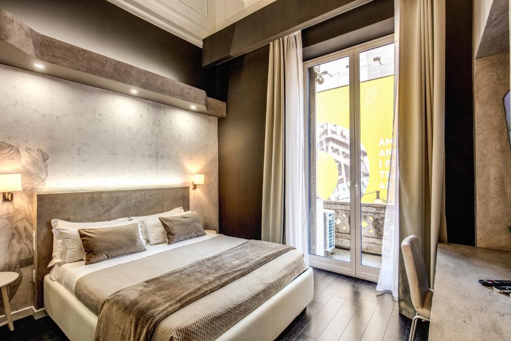 - une chambre avec un lit et une grande fenêtre dans l'établissement Four Rivers Suites, à Rome